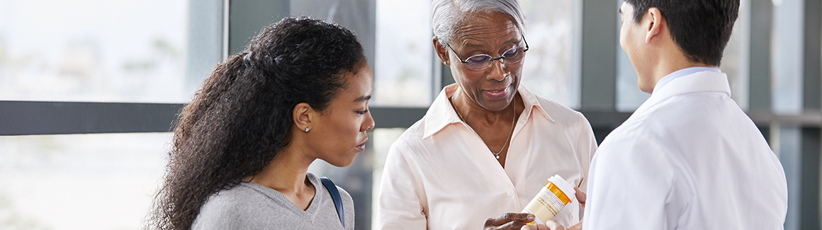 Woman and daughter speaking with doctor about prescriptions